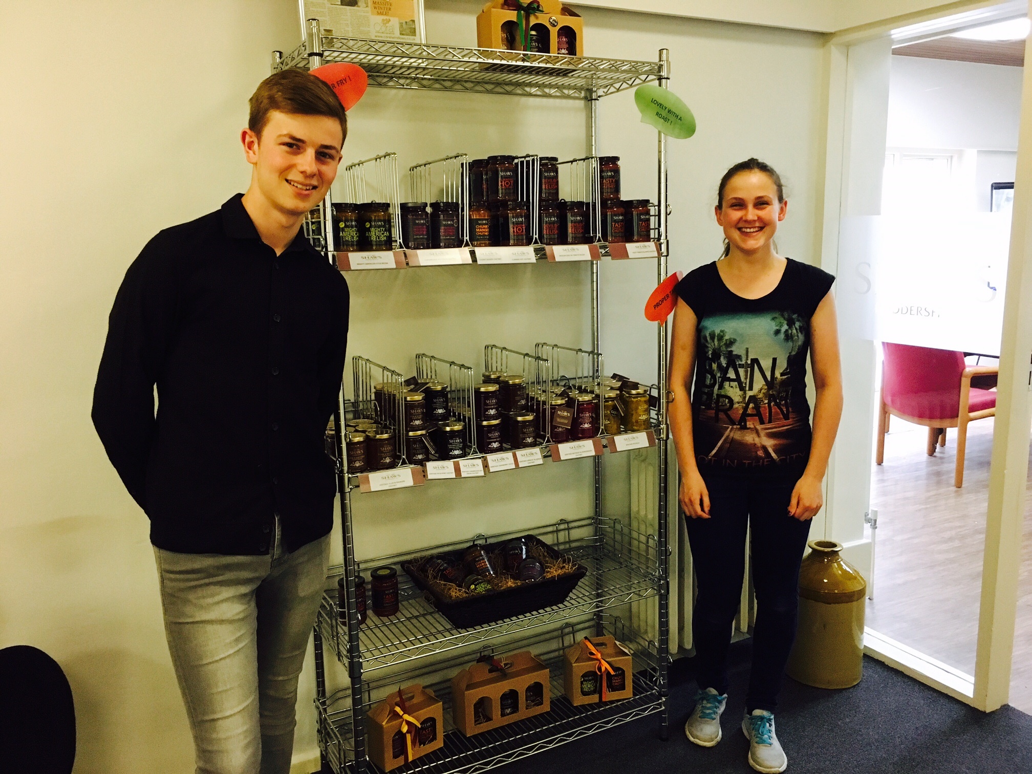 Harrison and Ruby stood next to Shaws chutney jars on their work experience